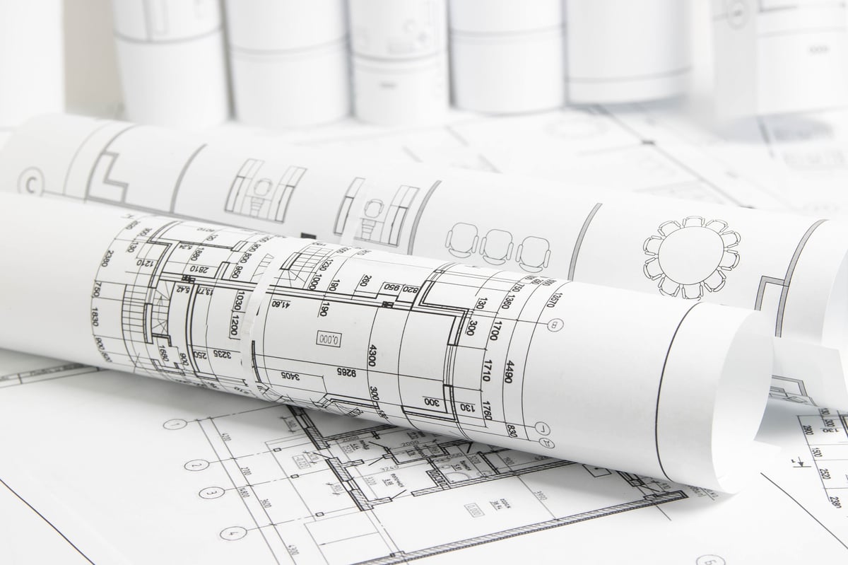 Architectural engineering house drawings and blueprints spread on a table