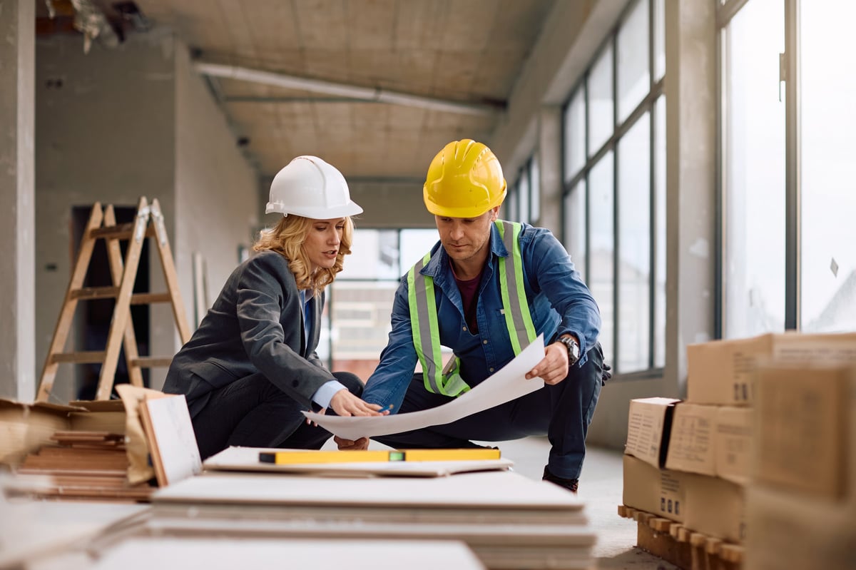 Engineer and developer examining construction plans together on site in Ontario