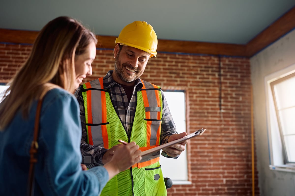 Building contractor and homeowner signing a renovation contract together