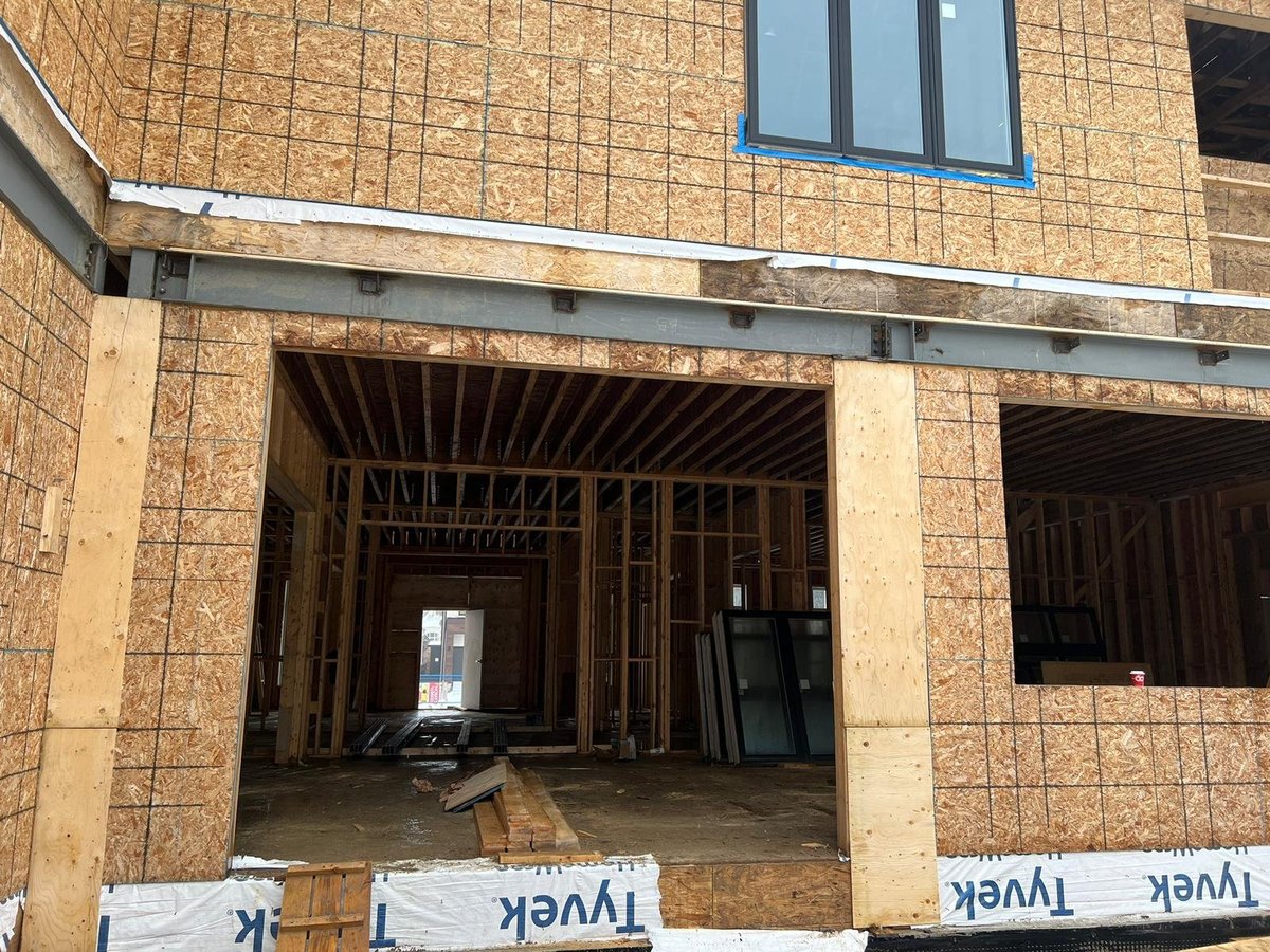 Unfinished brick building under construction with exposed wooden framing — shop drawings curtain wall glazing project in Toronto Ontario — MAY Engineering Inc.